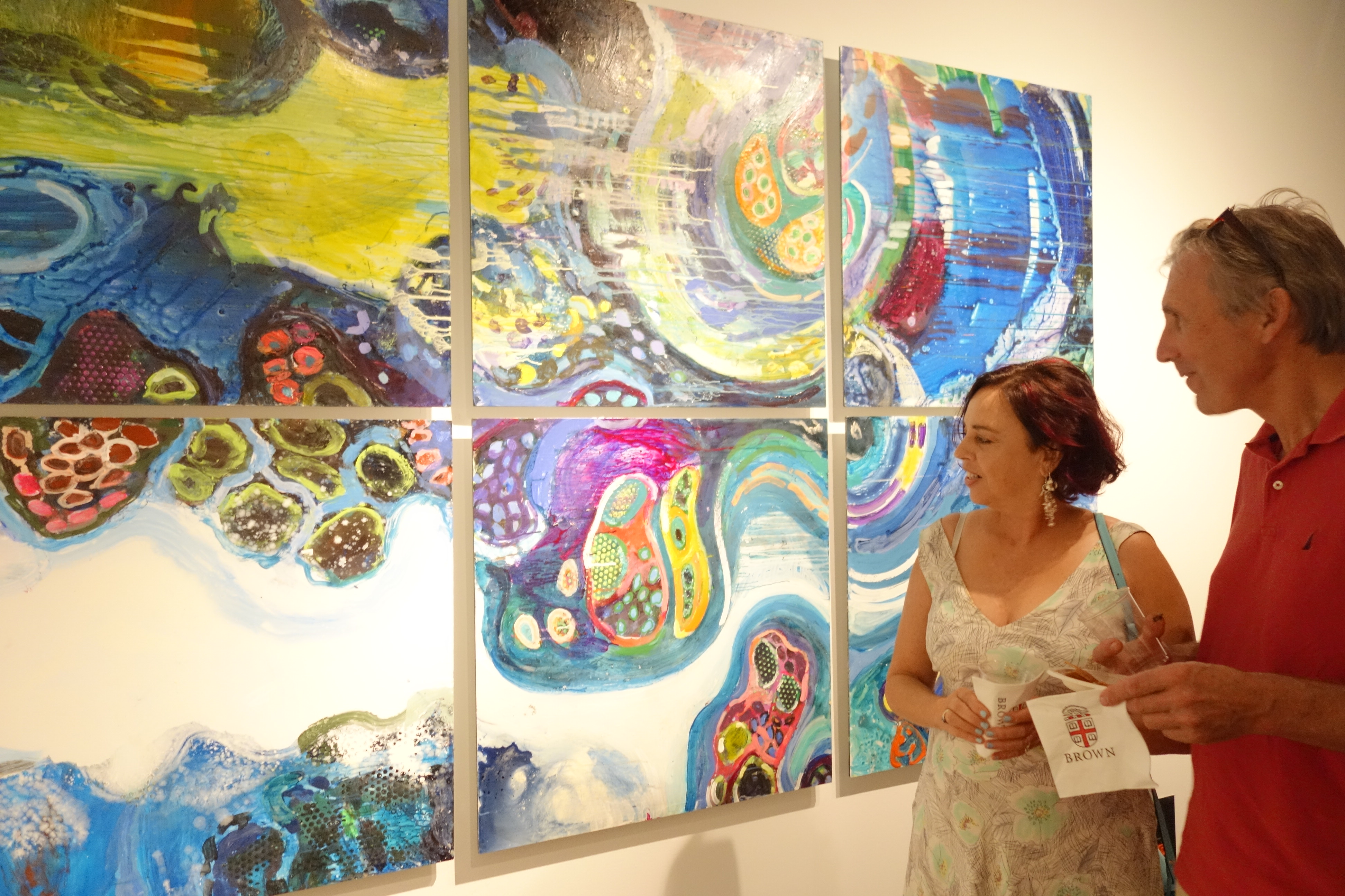 A woman standing in front of some paintings
